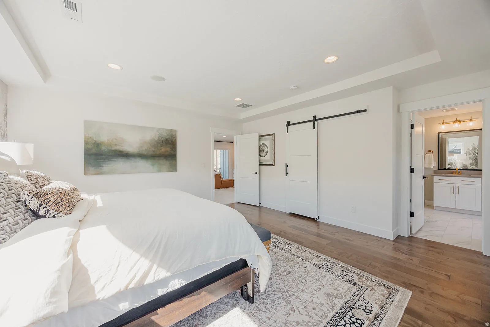 Bedroom featuring wood-finish flooring, recessed lighting, and a tray ceiling