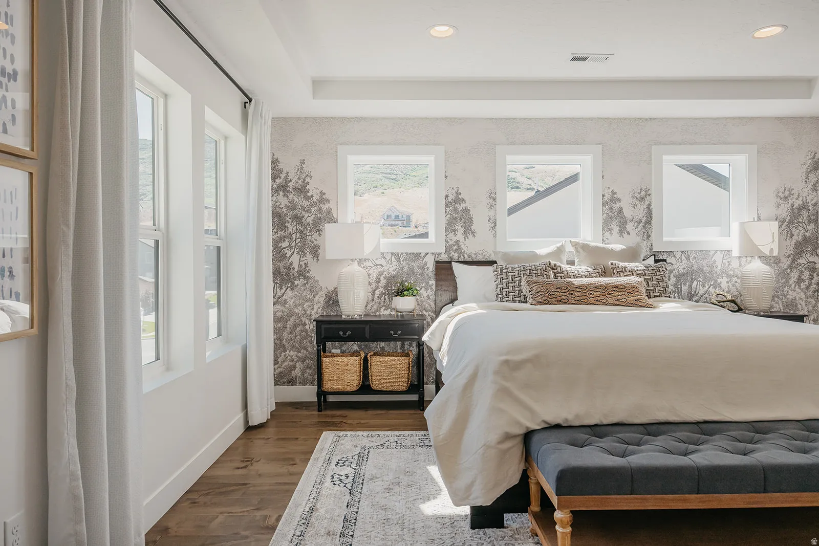 Spacious room featuring multiple windows, wood-finish flooring, recessed lighting, and a tray ceiling