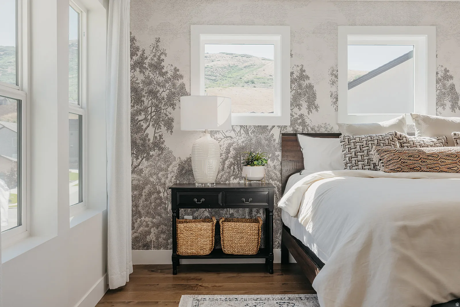 Wood-finish flooring complemented by a feature wall with a tree-patterned design
