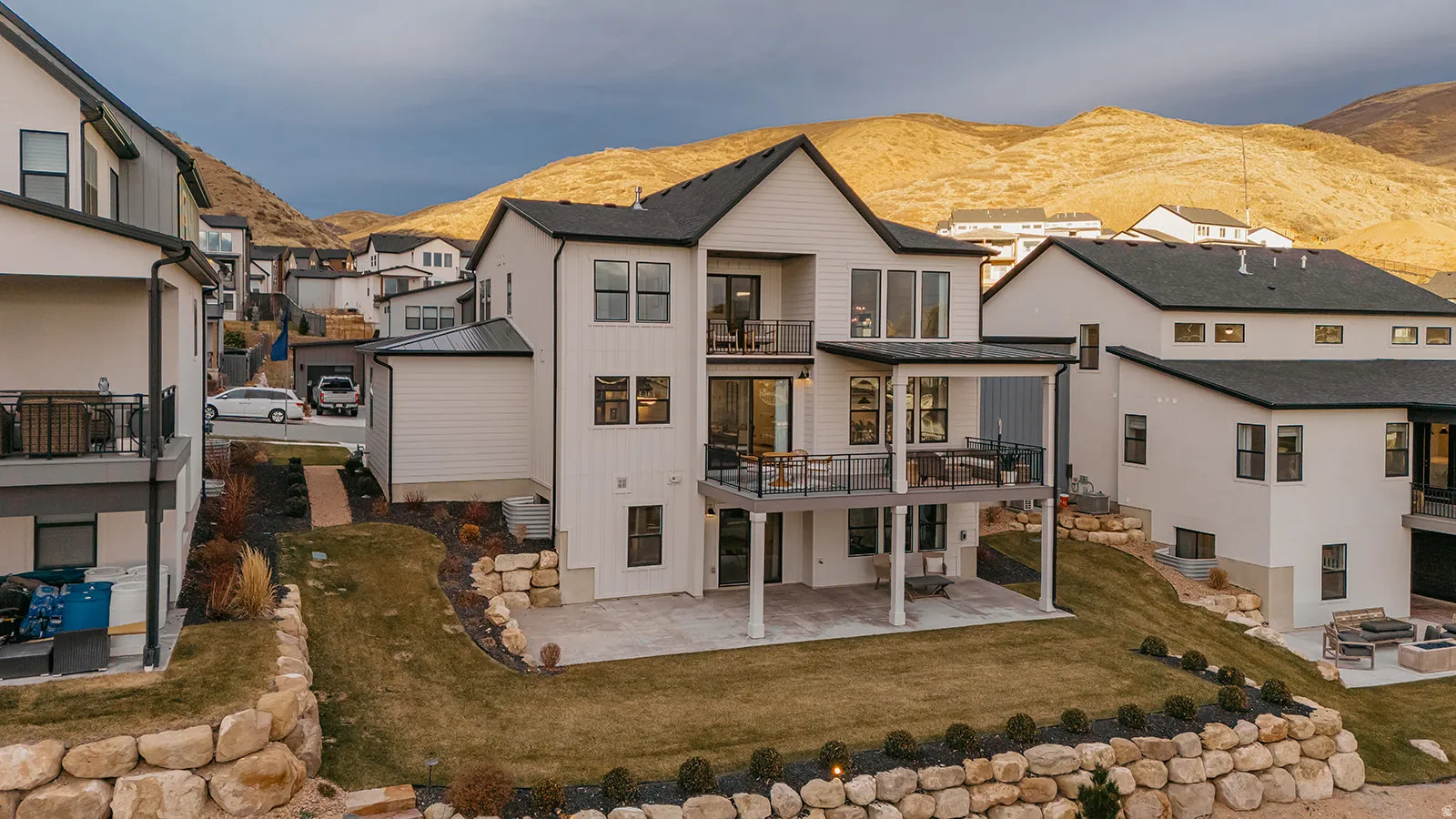 Contemporary home design featuring a white exterior with black trim and multiple outdoor living spaces