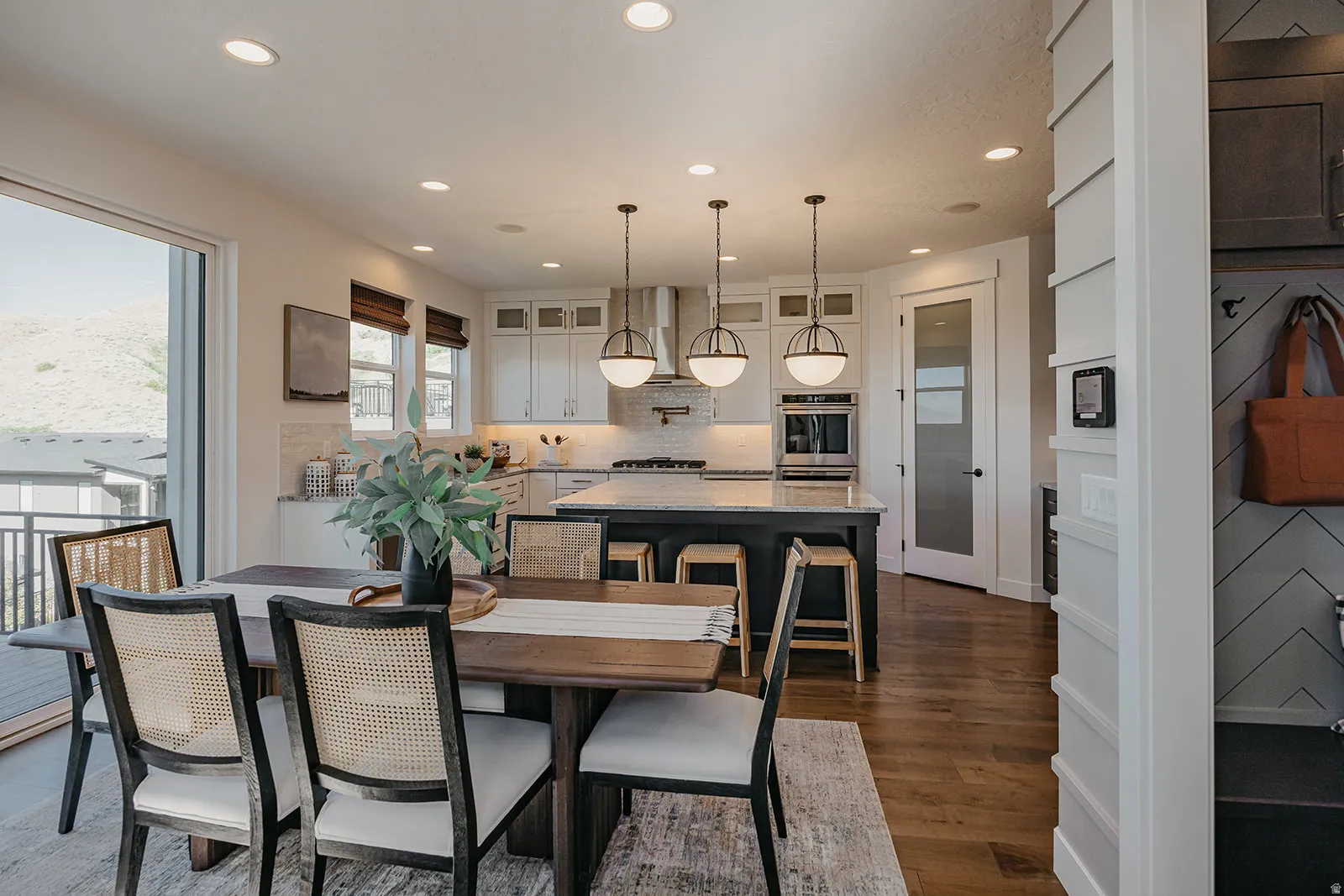 Open-concept living space featuring wood-finish flooring, recessed lighting, and a sliding glass door to an outdoor deck