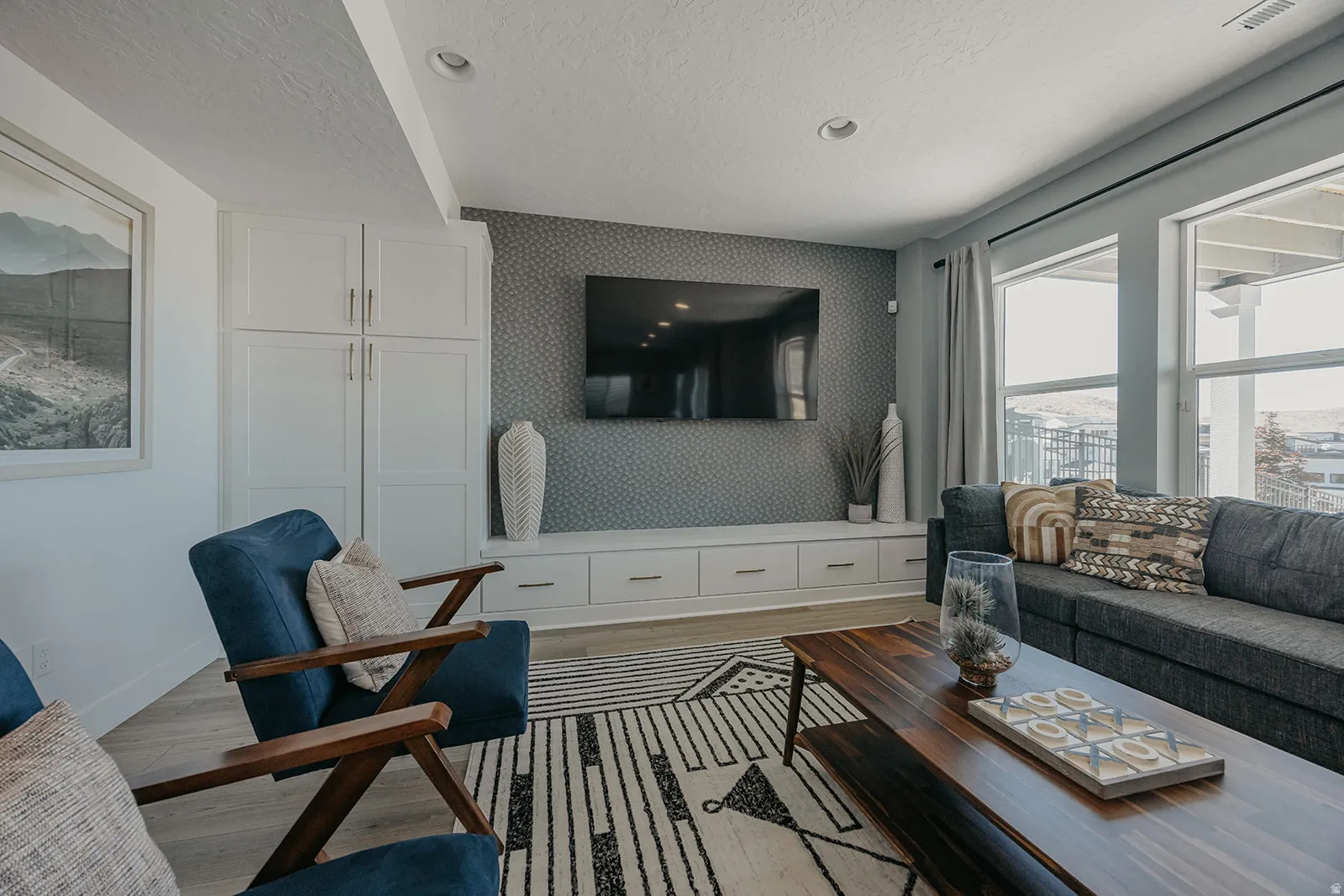 Living area featuring white built-in cabinetry, a media console with integrated storage, and multiple windows
