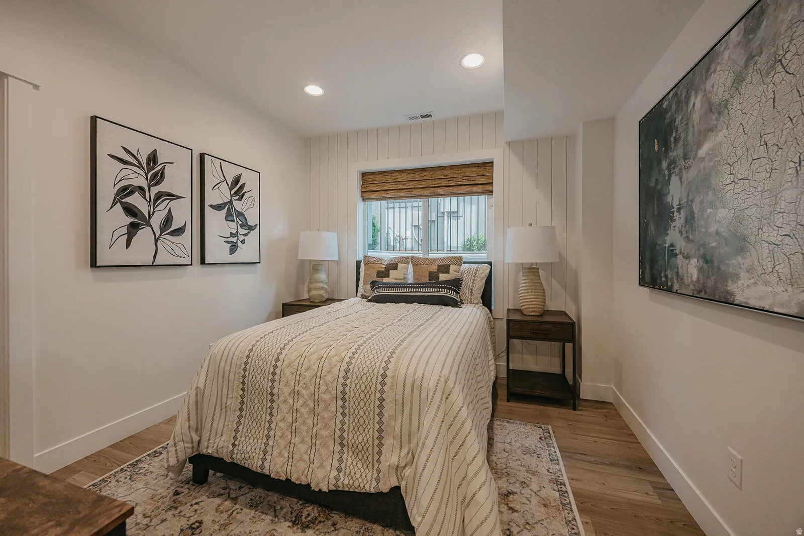 Bedroom featuring a window with a woven shade, recessed lighting, and wood-finish flooring