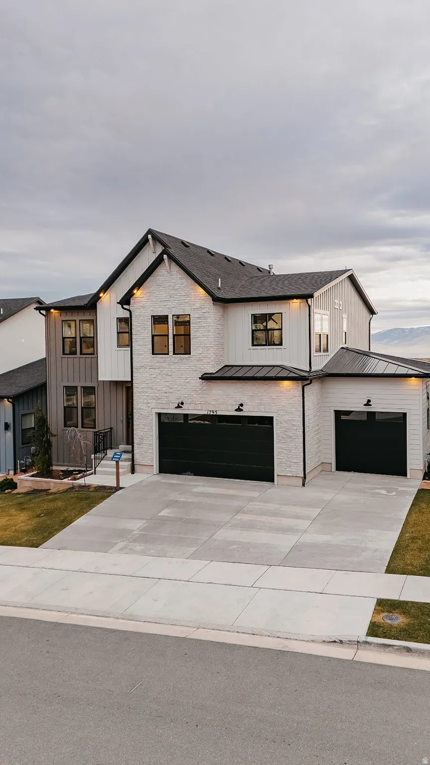 Contemporary residence featuring a white brick and vertical siding facade