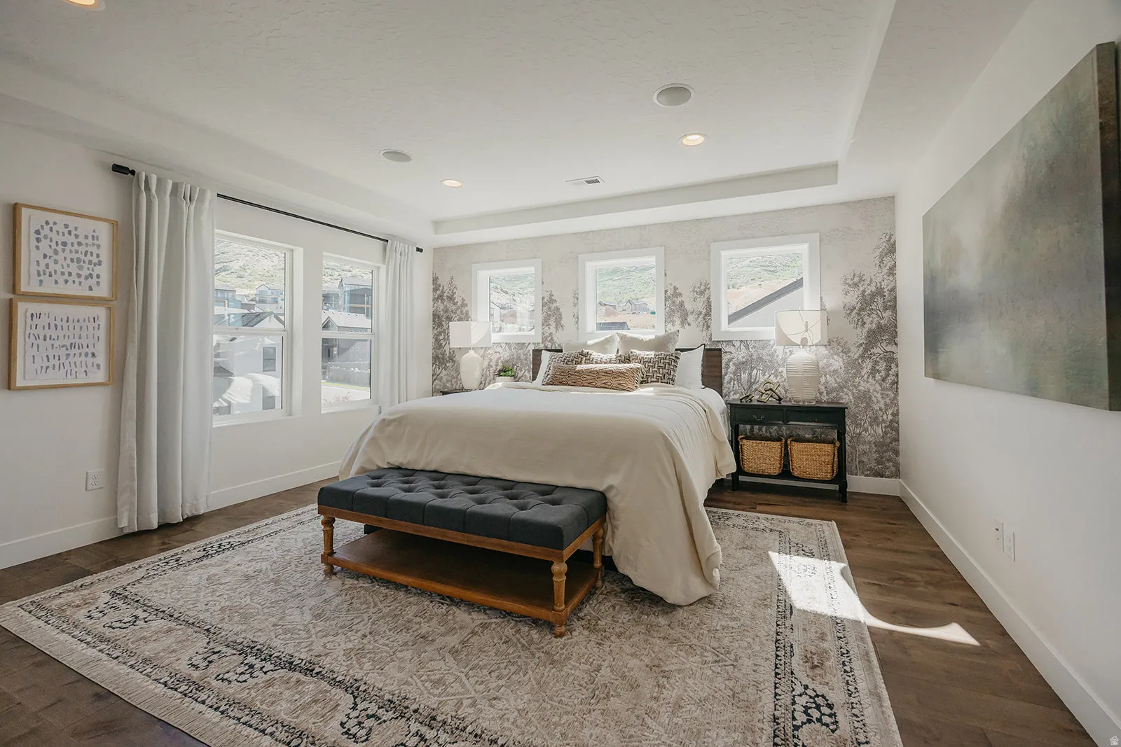 Spacious bedroom featuring wood-finish flooring, a tray ceiling, recessed lighting, and multiple windows