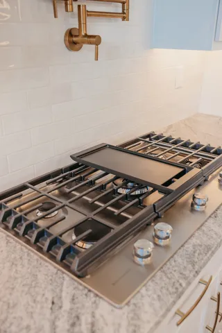 Built-in gas cooktop with a griddle feature, set into a speckled countertop