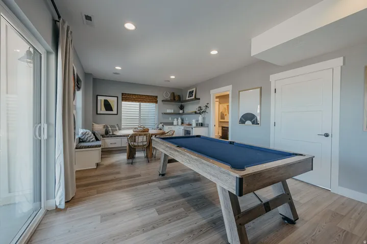 Spacious recreation room featuring wood-finish flooring and recessed lighting