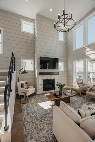 Living area featuring a floor-to-ceiling fireplace with stone surround and dark wood mantel