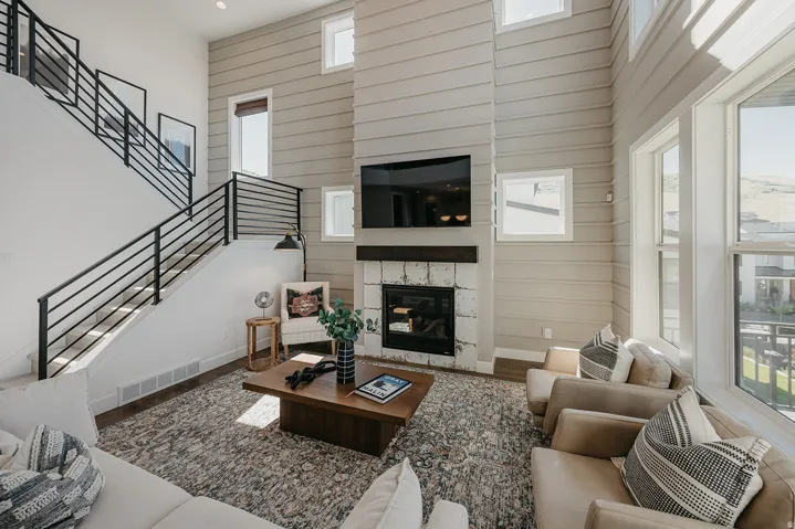 Two-story living area featuring a prominent fireplace with a stone surround and wood mantel