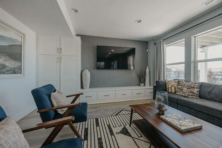 Living area featuring white built-in cabinetry, a media console with integrated storage, and multiple windows