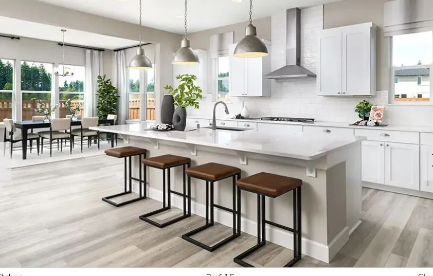 Open-concept kitchen featuring an oversized island with seating, pendant lighting, shaker-style cabinetry, a subway tile backsplash, and wood-finish flooring