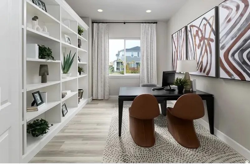 Built-in shelving with crown molding and base trim, light wood-finish flooring, recessed lighting, and a window with natural light