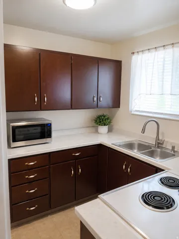 Unit B: U-shaped kitchen with wood-finish cabinetry and light-toned countertops