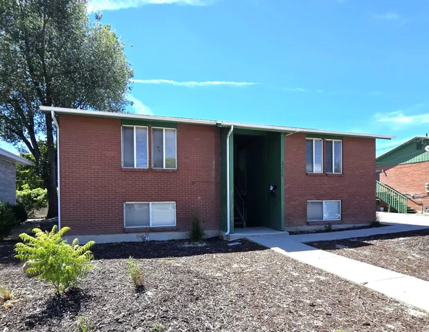 Brick-clad exterior with green fascia and white trim