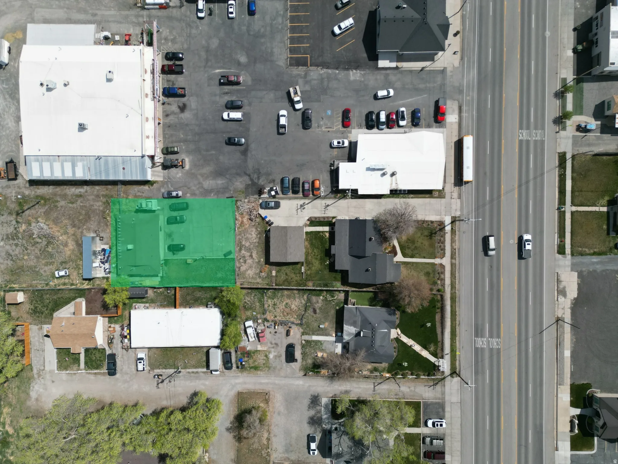Aerial depiction of a property featuring a prominent building with a light-colored roof
