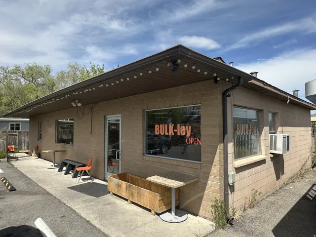 Commercial storefront featuring brick and horizontal siding, multiple display windows, and a covered entryway