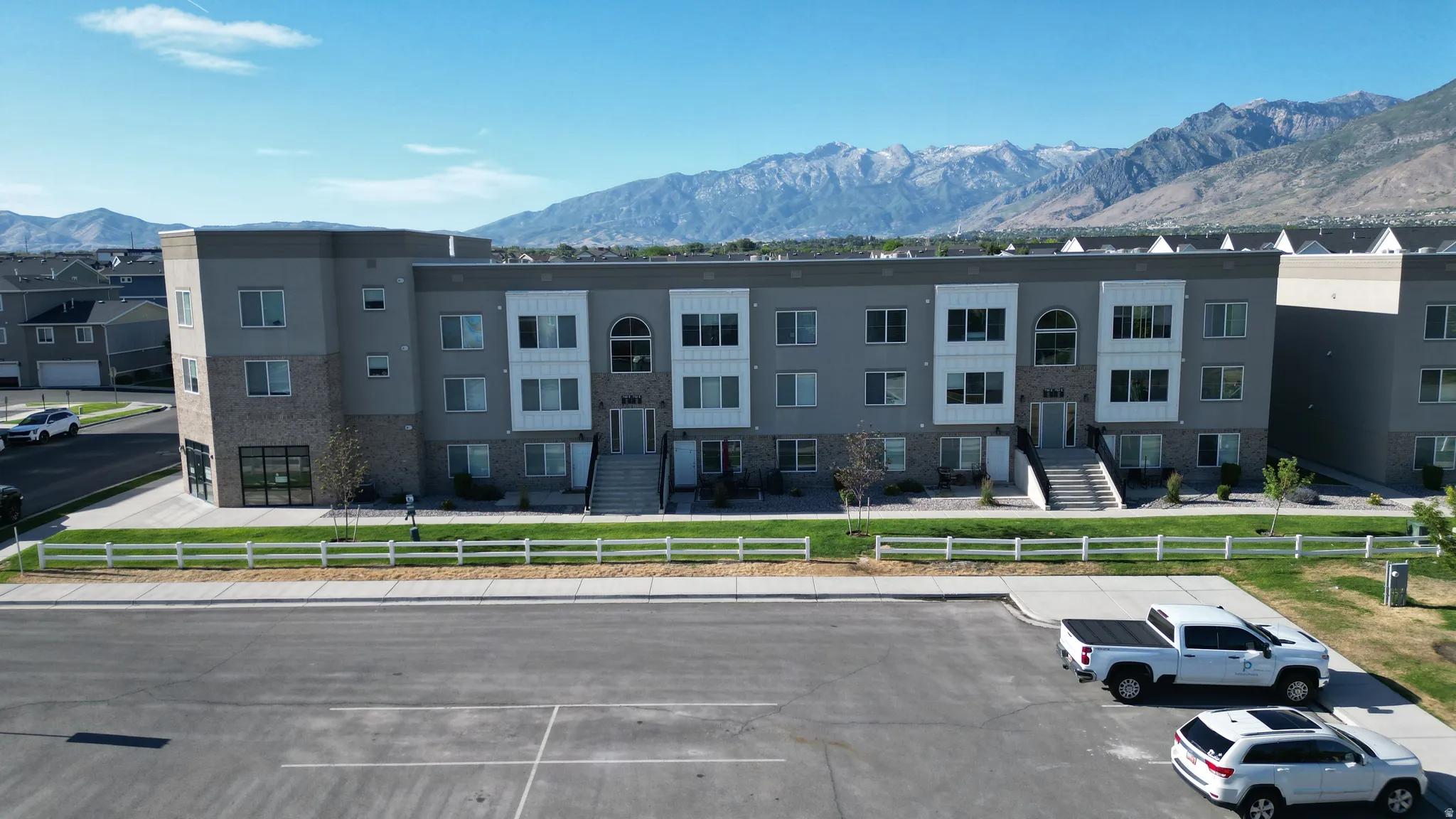 Contemporary multi-story building featuring a facade of light grey siding and white accents