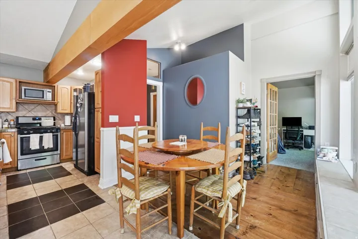 Kitchen area featuring stainless steel appliances, wood-finish cabinetry, and a checkerboard tile floor