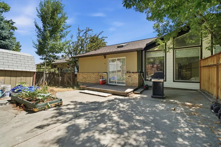 Expansive concrete patio with a wood-plank deck area
