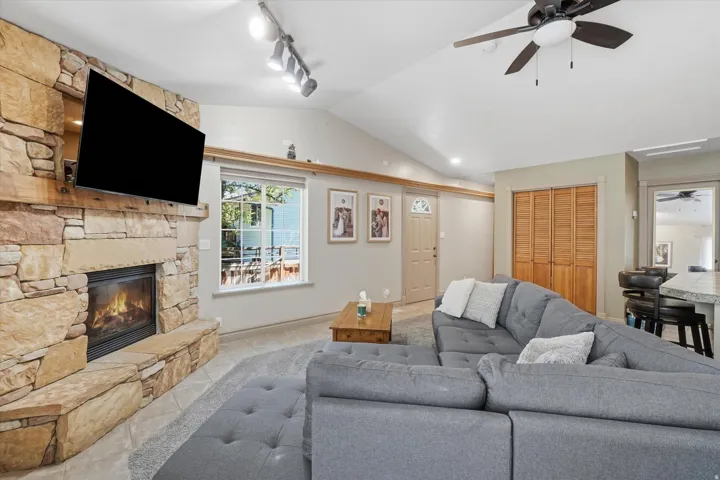 ADU with Vaulted ceilings enhance this living space featuring a stone-clad fireplace with a built-in hearth