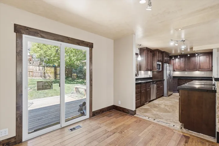 Kitchen with dark wood cabinetry, stainless steel appliances, and dark countertops