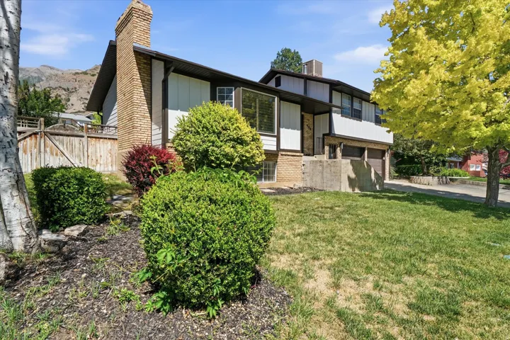 Split-level residence featuring a prominent brick chimney and a concrete foundation
