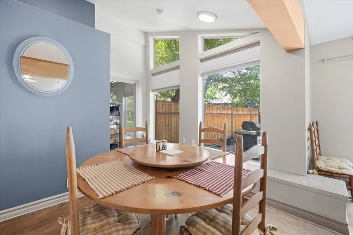 ADU Dining area featuring wood-finish flooring and a light blue accent wall with a circular mirror
