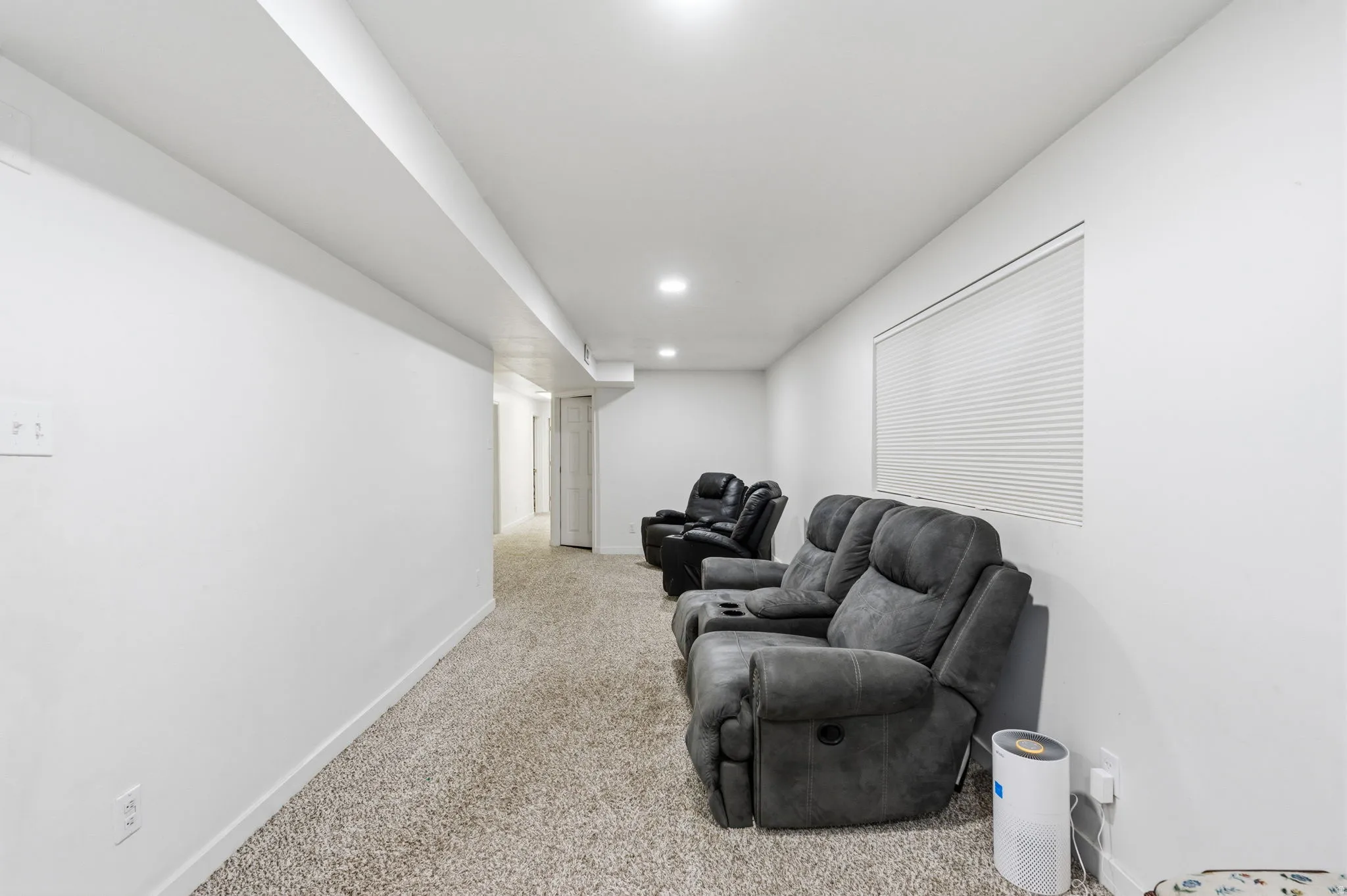 Carpeted room with recessed lighting and a window featuring horizontal blinds