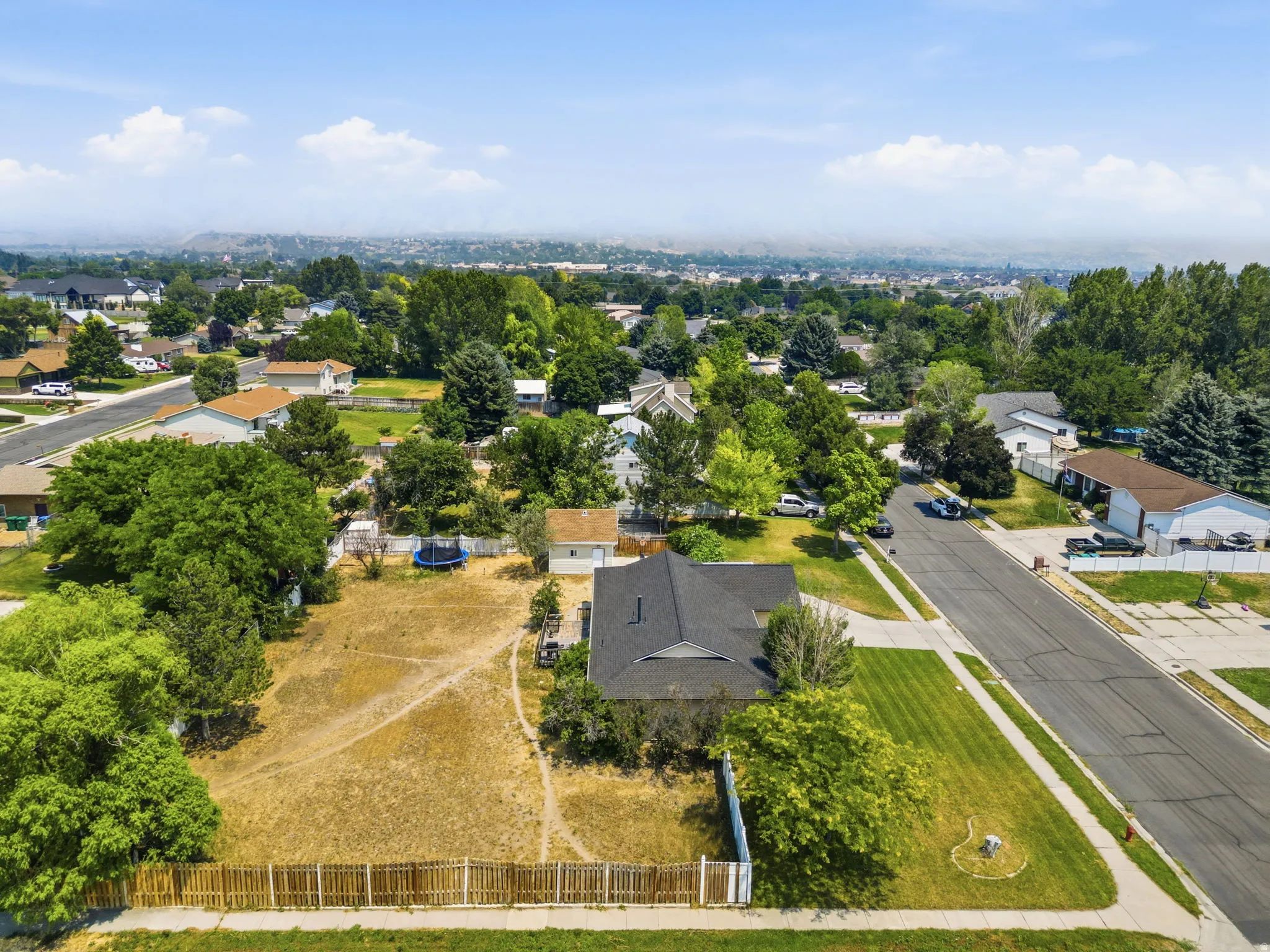 Expansive lot featuring a wooden fence and existing trees