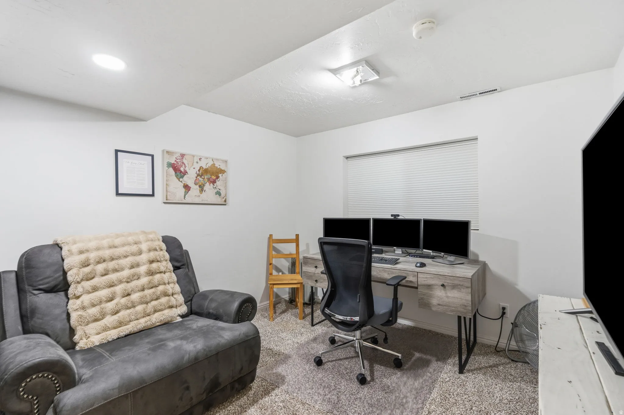 Carpeted room with recessed lighting and a window featuring horizontal blinds