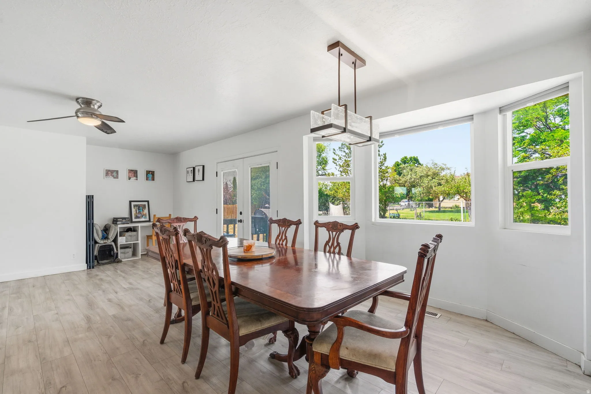 Bright dining area featuring wood-finish flooring and a contemporary linear chandelier