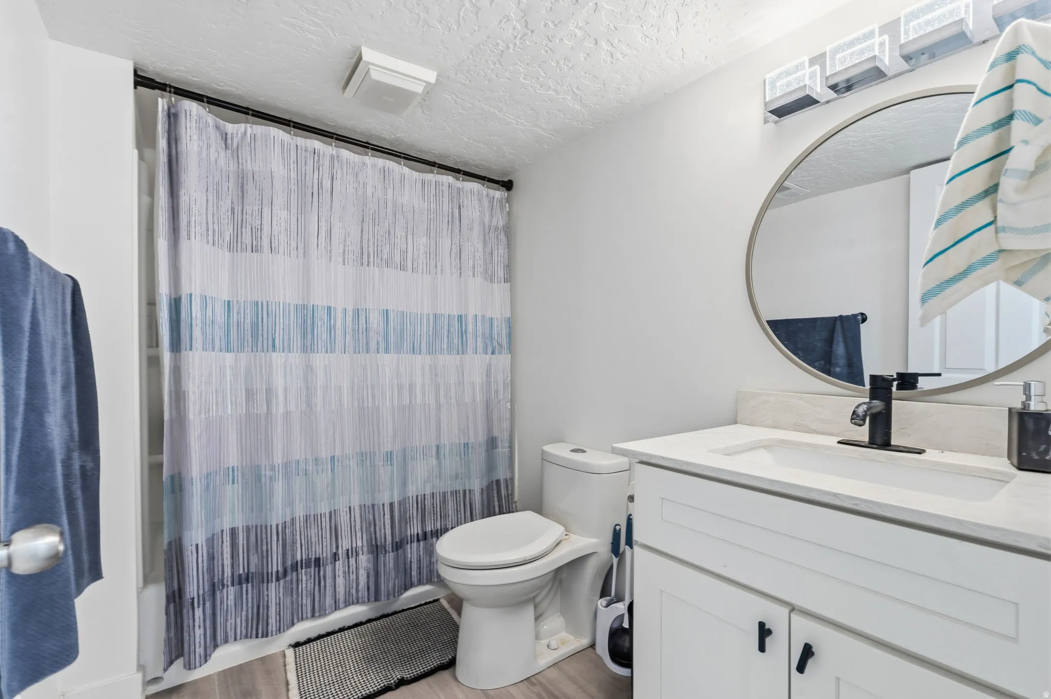 Bathroom featuring a single vanity with built-in cabinetry, an undermount sink, and a black faucet