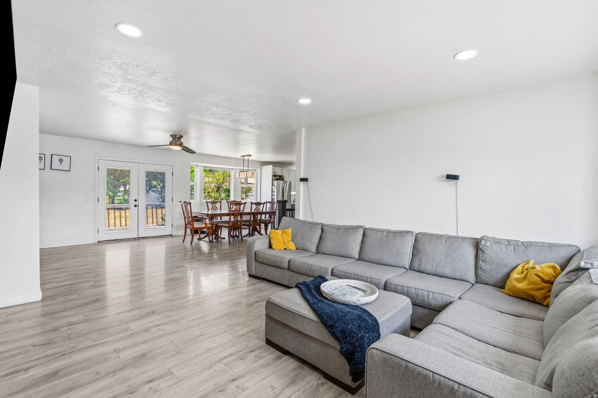 Spacious living area featuring light wood-finish flooring and recessed ceiling lighting