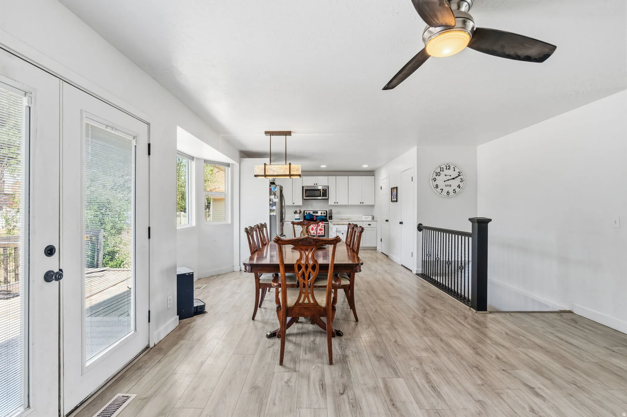 Open-concept dining area featuring wood-finish flooring, a contemporary chandelier, and recessed lighting