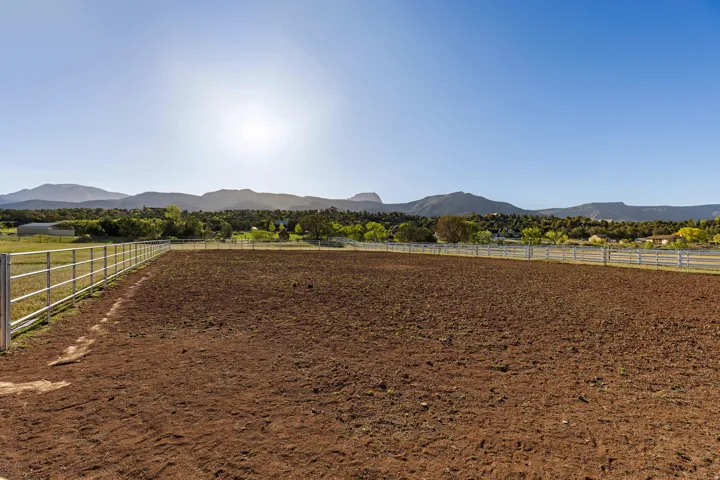 Expansive unpaved parcel enclosed by a metal perimeter fence