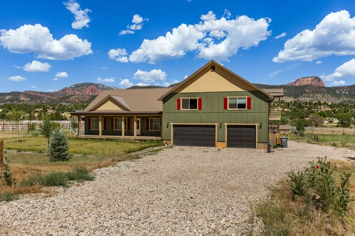 Two-story residence featuring a metal roof, two-car garage, and a covered front porch