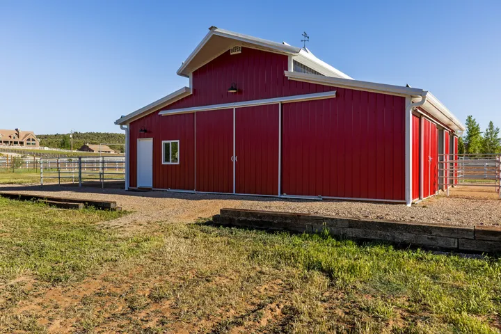 Red barn structure featuring white trim and a gabled roof