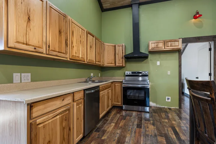 Kitchen featuring natural wood cabinetry, light-toned countertops, and a stainless steel appliance suite