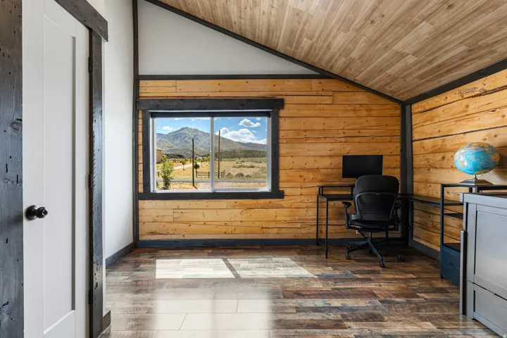 Interior room with wood-finish flooring, natural wood plank walls, and a wood-paneled vaulted ceiling