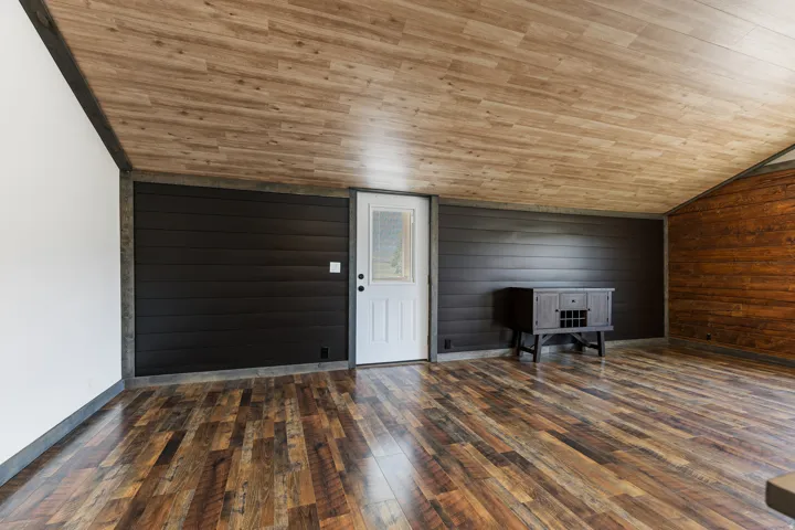 Warm wood-finish flooring complements the angled wood-finish ceiling