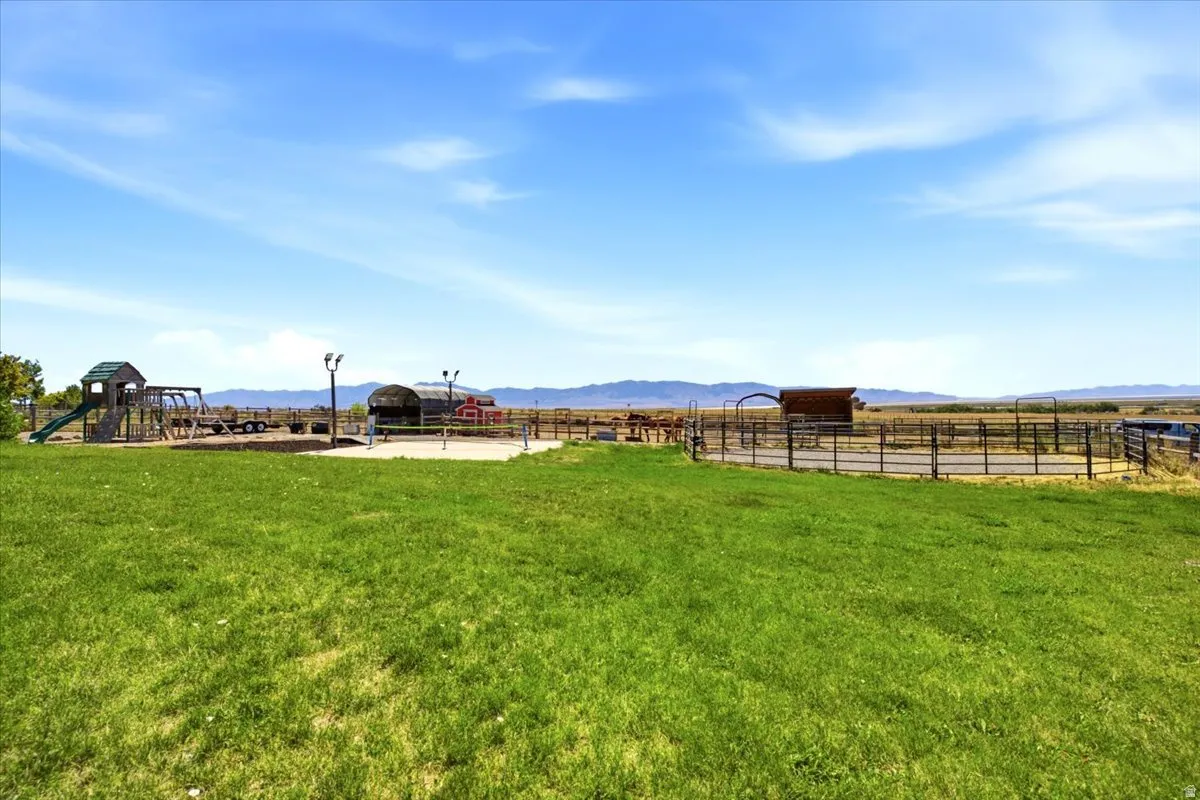 Expansive grassy yard area with distant mountain backdrop