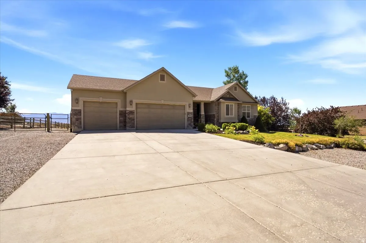 Exterior featuring a two-car garage, stucco and stone facade, and a concrete driveway