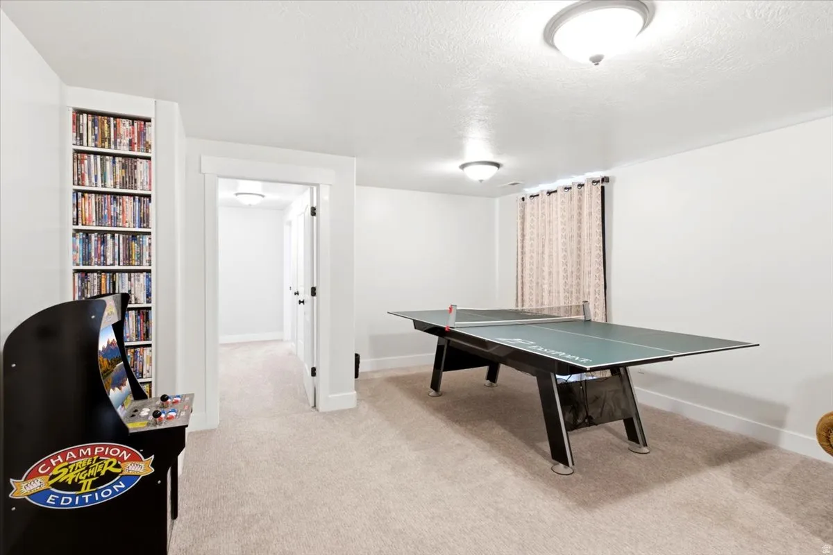 Spacious room with plush carpet flooring, recessed shelving, and a window with neutral-toned drapes