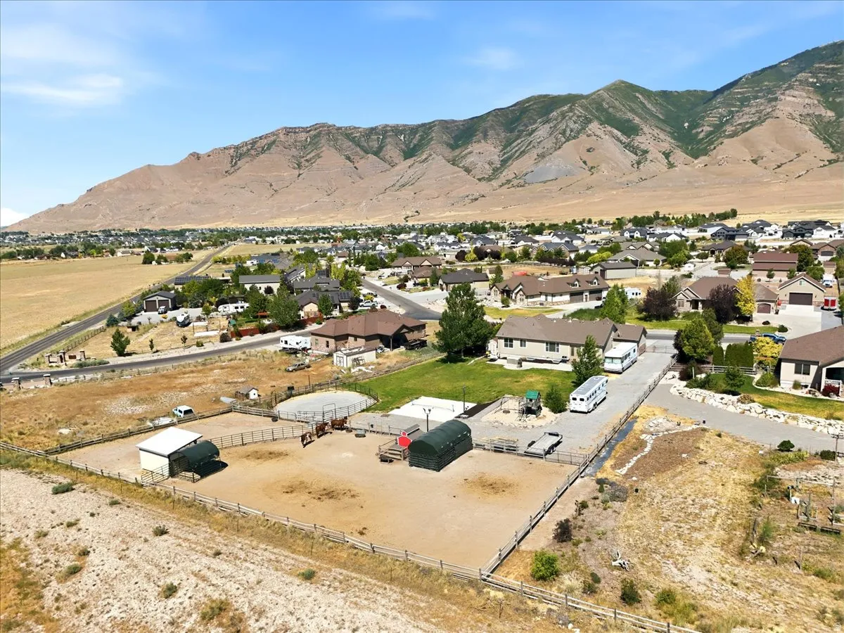 Expansive property featuring a fenced paddock, barn structure, and mountain backdrop