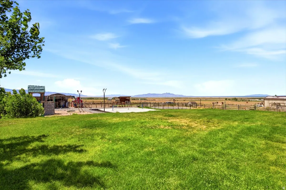 Expansive outdoor area featuring a wide grass lawn and distant mountain scenery