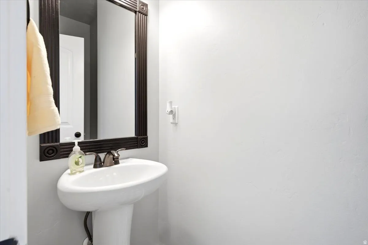 Pedestal sink with oil-rubbed bronze faucet and framed mirror