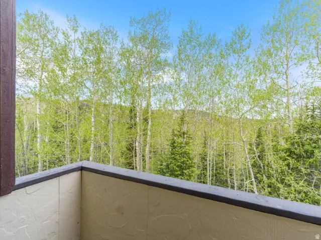 Outdoor balcony featuring textured stucco walls and a dark cap railing