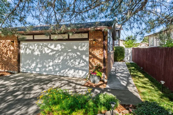 Brick facade with decorative half-timbering, an attached garage, and a paved driveway