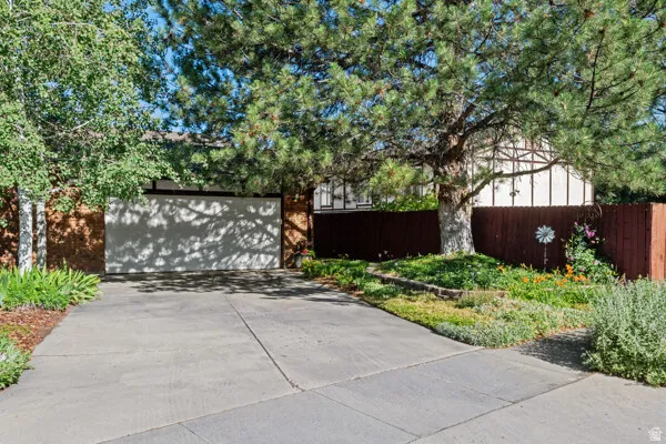 Concrete driveway leading to an attached garage with a white door