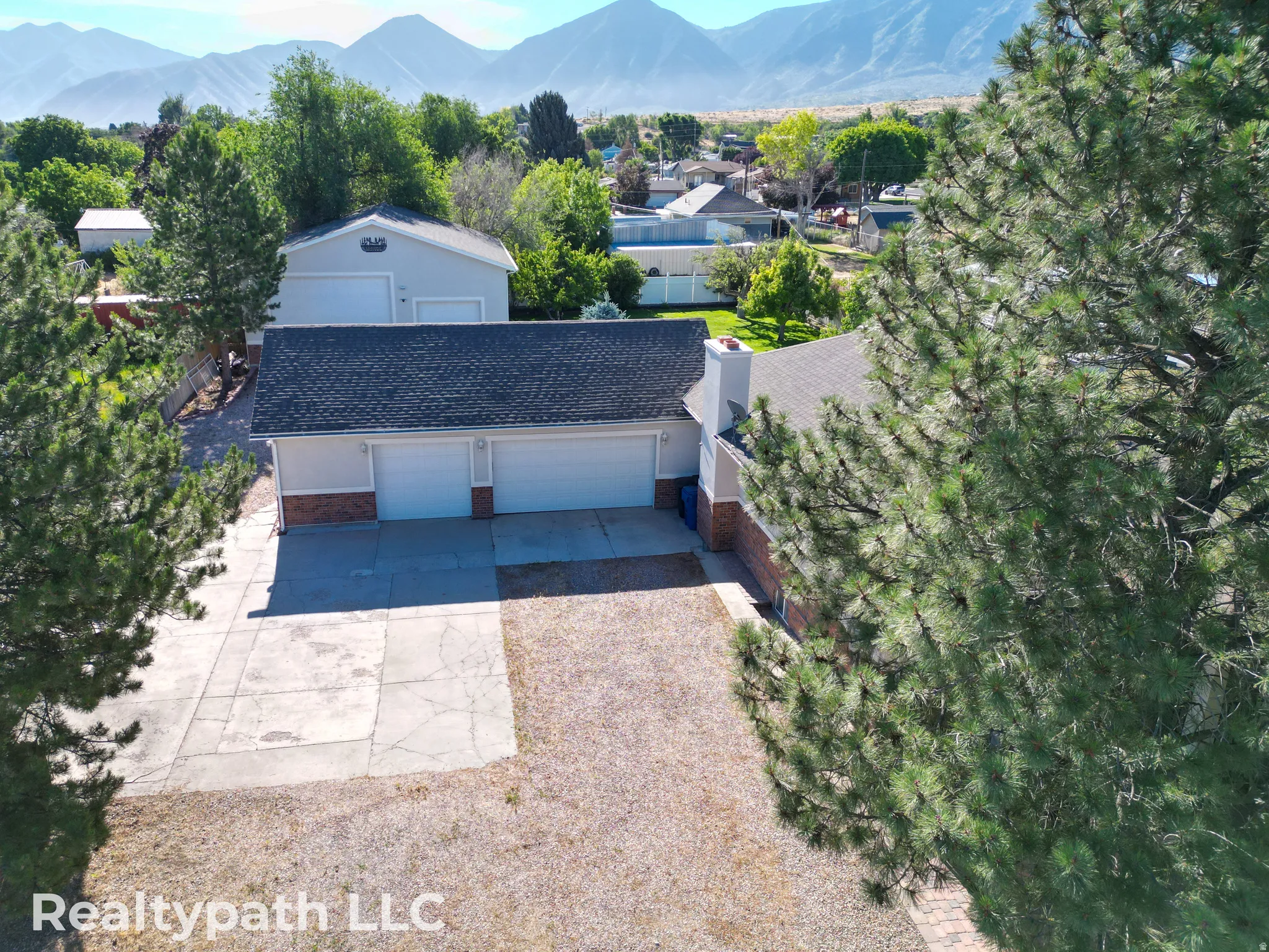 Property featuring a multi-car garage, an additional detached garage structure, and a paved driveway